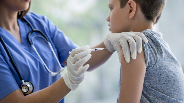 Imagen de un especialista de salud vacunando a un niño