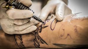 Imagen de una persona tatuando a otra
