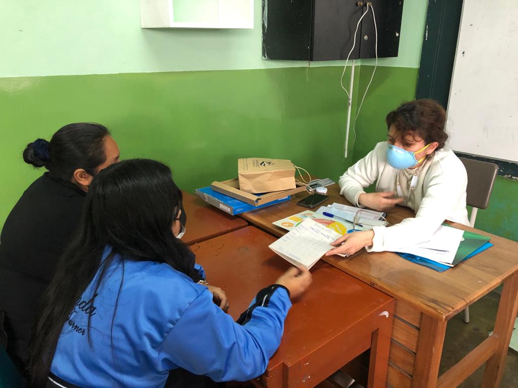Imagen de un personal de la salud orientando a un adolescente en compañia de su madre